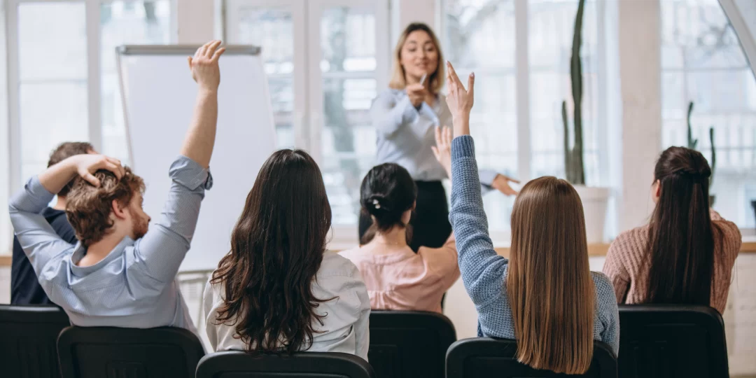 female-speaker-giving-presentation-hall-university-workshop-audience-conference-hall-1080x540.webp